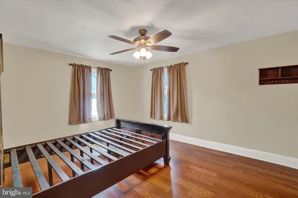 a view of an empty room with window and chandelier fan