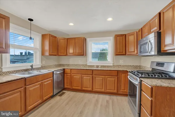 a kitchen with stainless steel appliances granite countertop wooden cabinets a sink and a stove