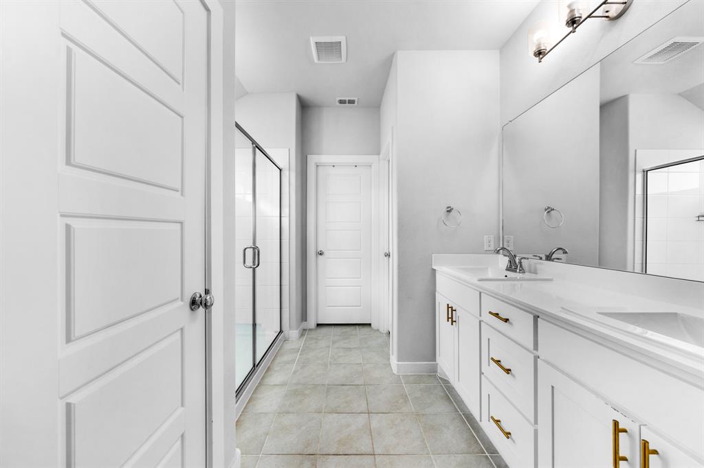 1012 Breezy Street Princeton, TX 75407 - Photo 12 of 34 a spacious bathroom with a granite countertop sink a mirror and a shower