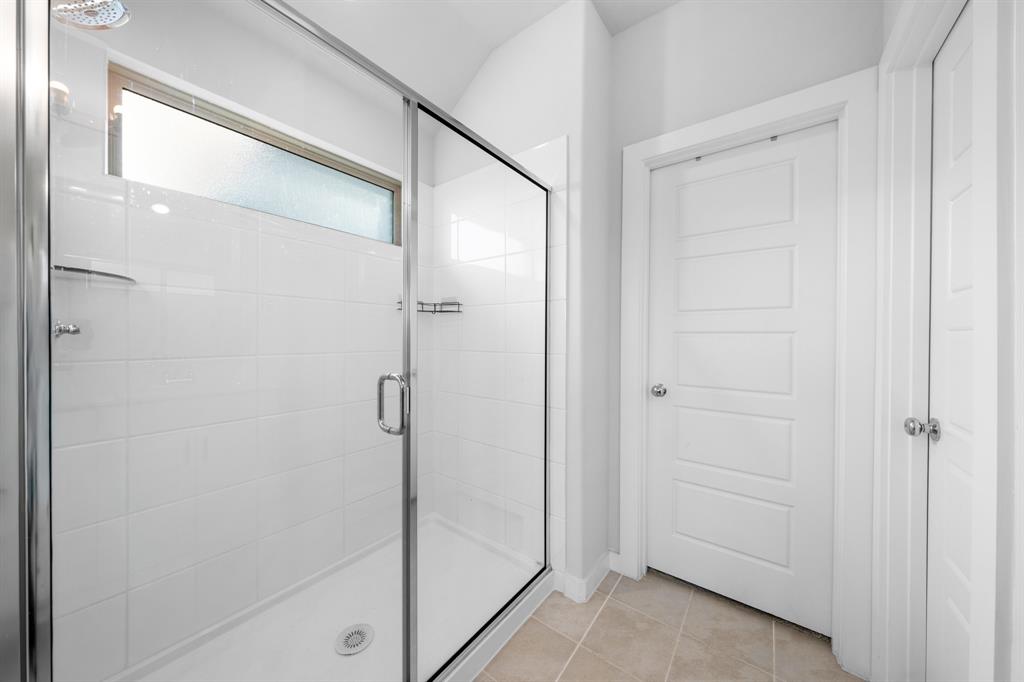 1012 Breezy Street Princeton, TX 75407 - Photo 14 of 34 a bathroom with a glass shower door
