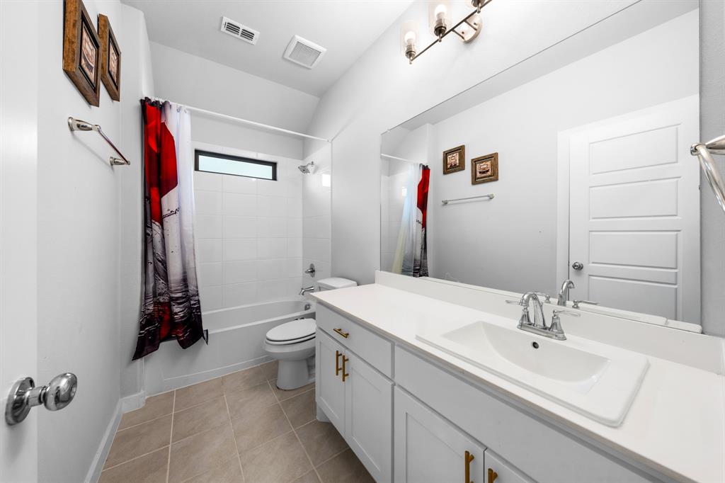 1012 Breezy Street Princeton, TX 75407 - Photo 20 of 34 a bathroom with a sink a toilet and a mirror