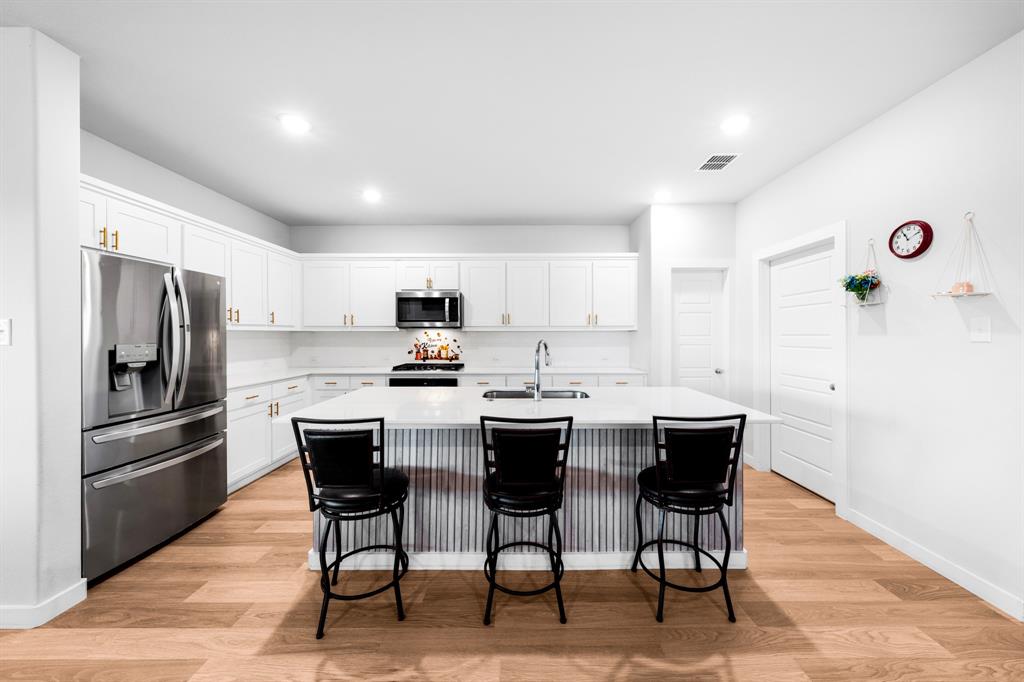 1012 Breezy Street Princeton, TX 75407 - Photo 2 of 34 a kitchen with stainless steel appliances a dining table chairs refrigerator and sink