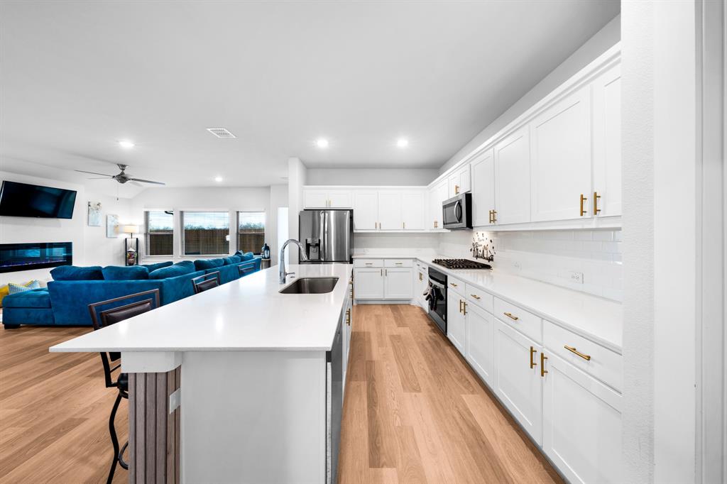 1012 Breezy Street Princeton, TX 75407 - Photo 5 of 34 a large kitchen with stainless steel appliances lots of counter space and wooden floor