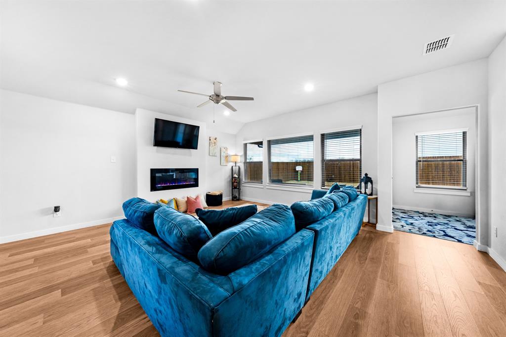 1012 Breezy Street Princeton, TX 75407 - Photo 7 of 34 a living room with furniture a fireplace and a wooden floor