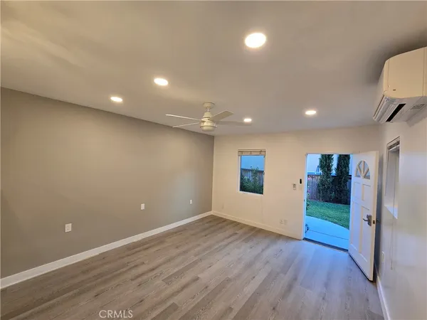 an empty room with wooden floor and entryway