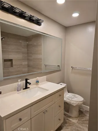 a bathroom with a sink a toilet and mirror