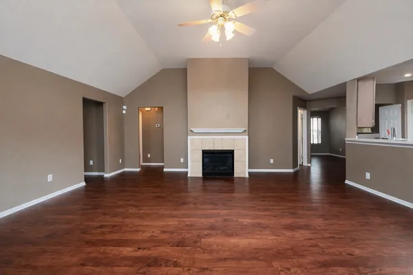 a view of a livingroom with wooden floor and a fireplace