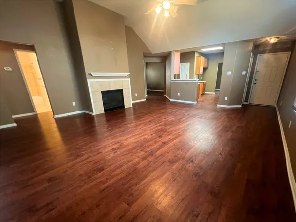 an empty room with wooden floor and fireplace