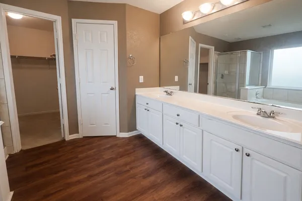 a spacious bathroom with a double vanity sink and mirror