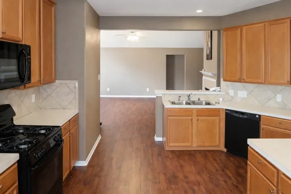 a kitchen with a sink stove top oven and cabinets