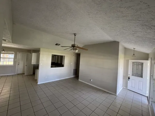 an empty room with fan and windows