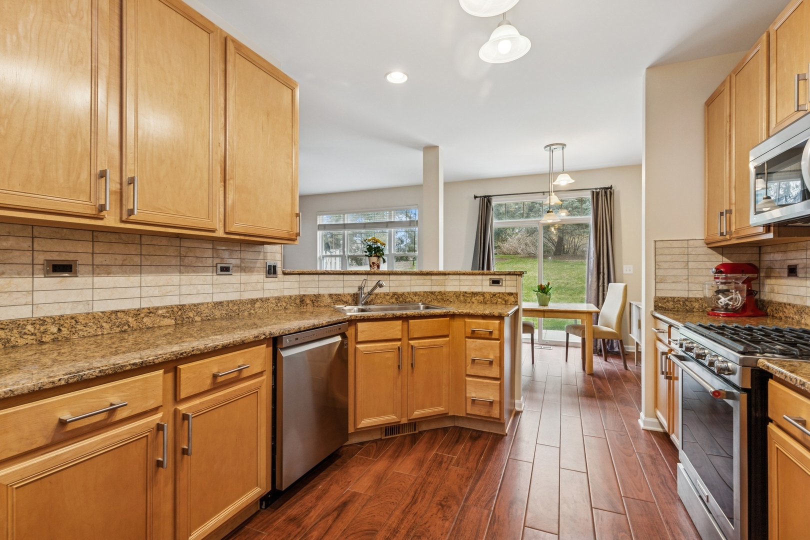 480 Pine Lake Circle Vernon Hills, IL 60061 - Photo 4 of 15 a kitchen with stainless steel appliances granite countertop wooden cabinets a sink a stove a dining table and chairs