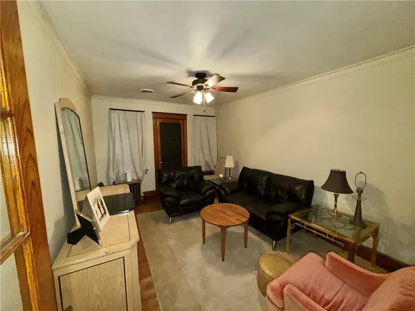 a living room with furniture and a ceiling fan