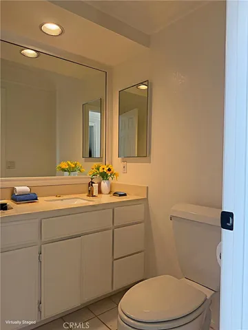 a bathroom with a toilet a sink a mirror and vanity