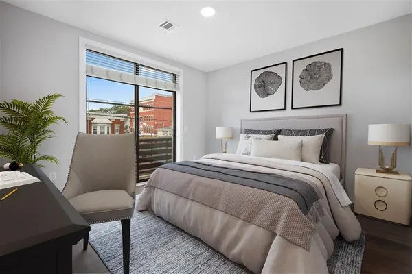a bedroom with a large bed and a painting on the wall