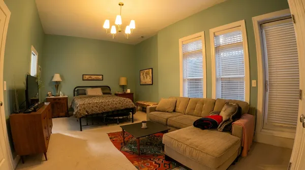 a bedroom with bed couch and window
