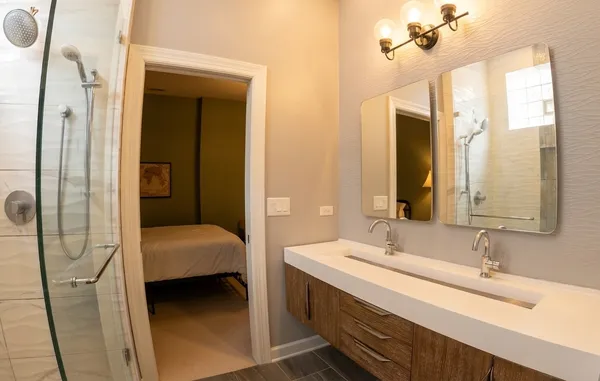 a en suite bathroom with a double vanity sink a mirror and shower