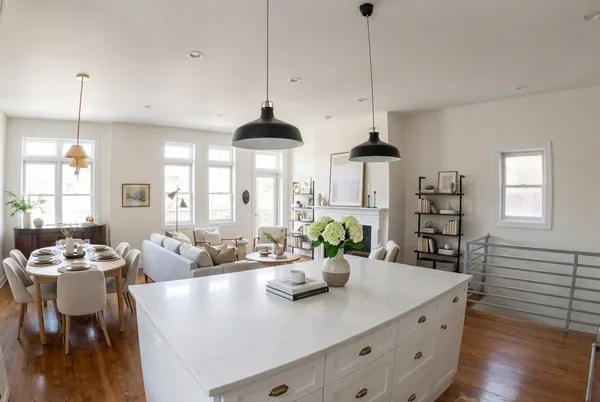 a view of a dining room and livingroom with furniture wooden floor a chandelier