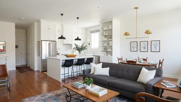 a living room with furniture kitchen and a table