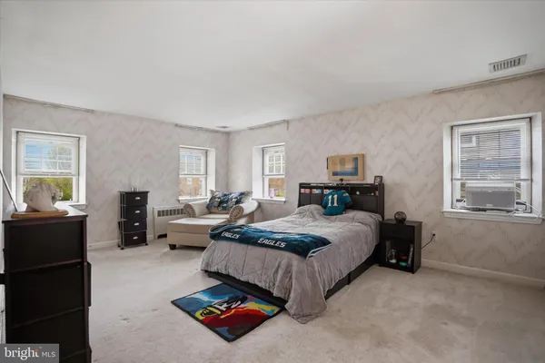 a bedroom with bed couch and window