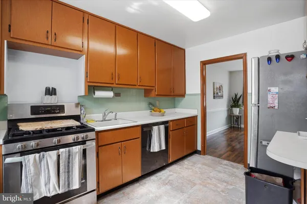 a kitchen with stainless steel appliances a stove a sink and cabinets