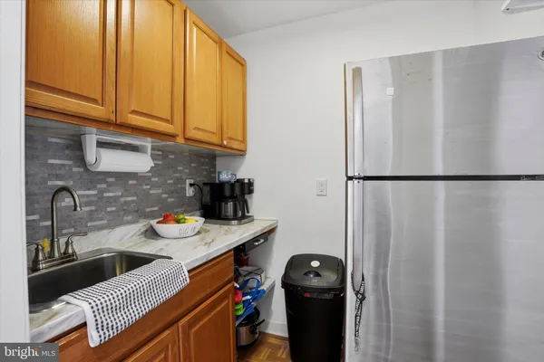 a kitchen with stainless steel appliances granite countertop a refrigerator a sink and a stove