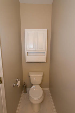 2422 Courtyard Circle, Unit 3 Aurora, IL 60506 - Photo 13 of 25 a white toilet sitting in a bathroom next to a sink