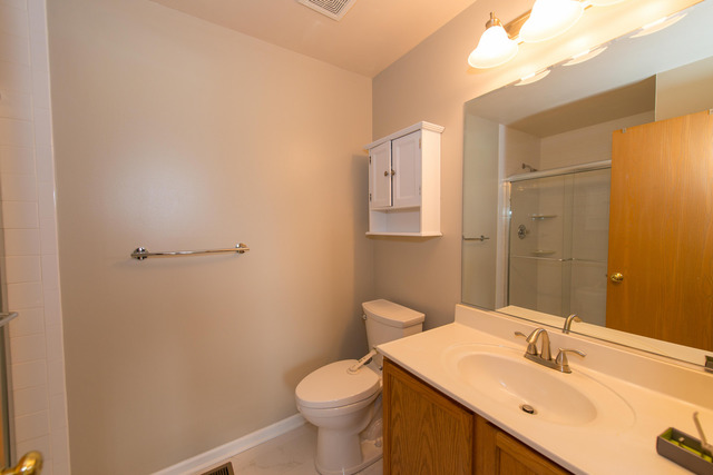 2422 Courtyard Circle, Unit 3 Aurora, IL 60506 - Photo 18 of 25 a bathroom with a sink a toilet and mirror