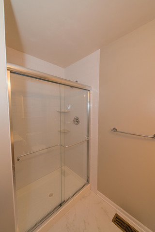 2422 Courtyard Circle, Unit 3 Aurora, IL 60506 - Photo 19 of 25 a bathroom with a glass shower door