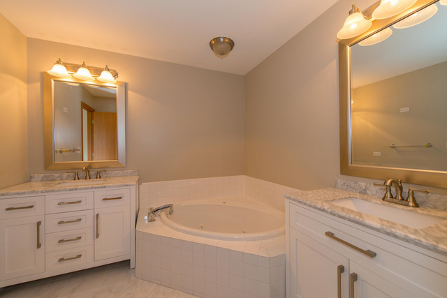 2422 Courtyard Circle, Unit 3 Aurora, IL 60506 - Photo 21 of 25 a bathroom with a granite countertop sink tub and a mirror