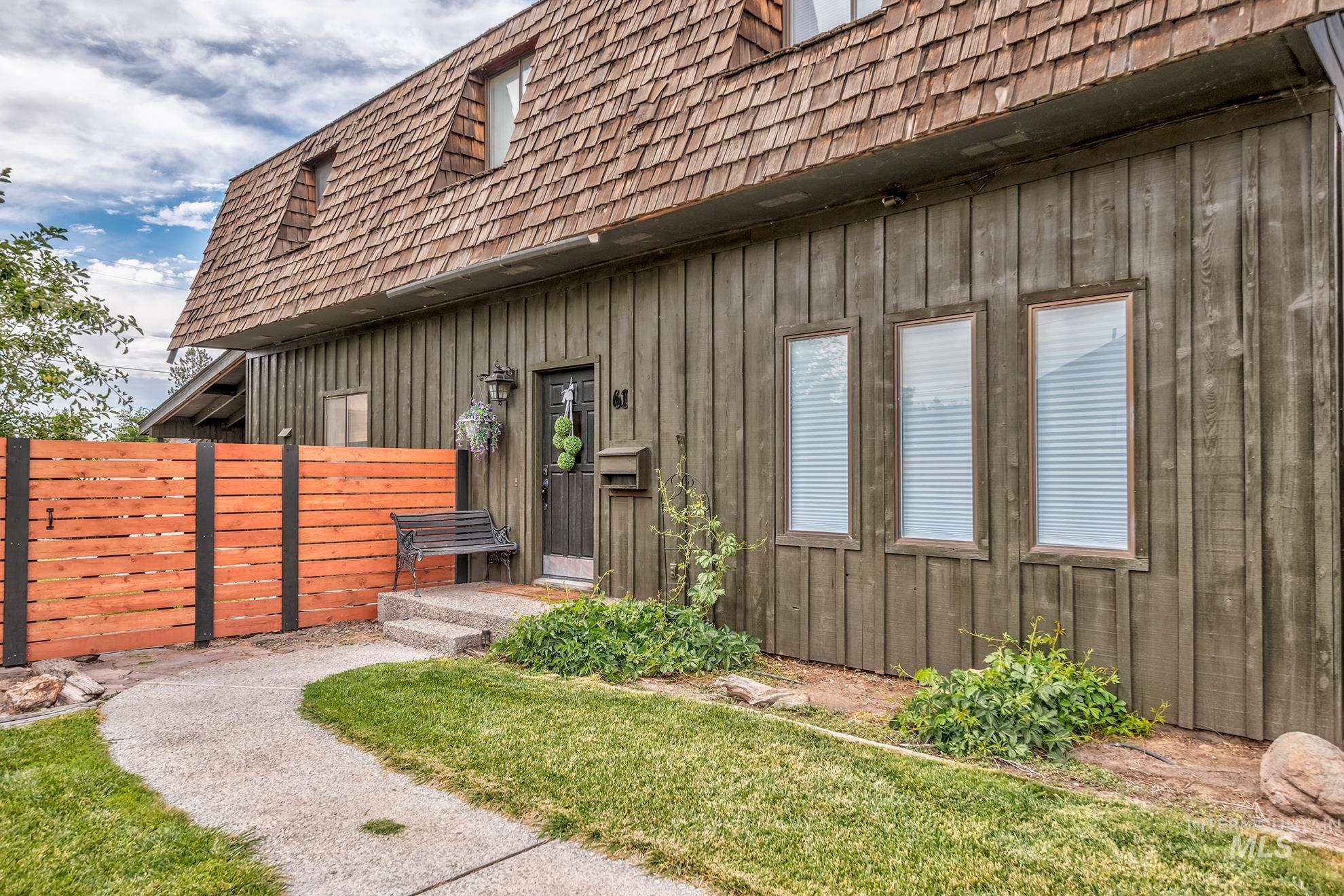 61 Southwest 4th Street Ontario, OR 97914 - Photo 34 of 42 Property exterior featuring a cedar shake mansard roof, vertical wood siding, and a privacy fence