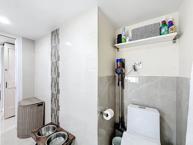 a kitchen with a sink dishwasher and white cabinets with wooden floor
