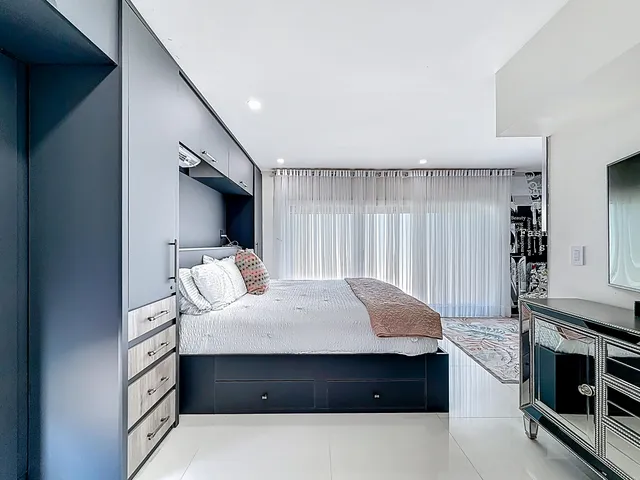 a spacious bedroom with a bed and a cabinets