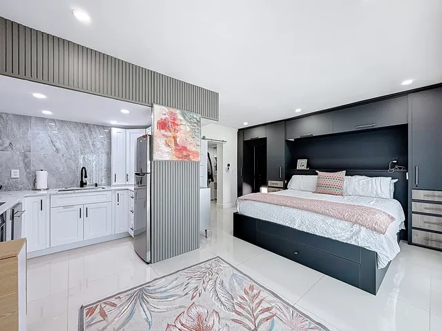 a spacious bedroom with a bed and a large mirror