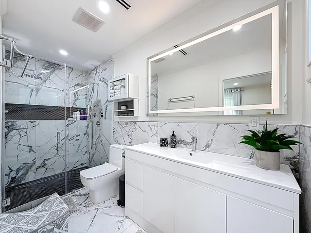 a large kitchen with stainless steel appliances kitchen island granite countertop a table chairs and a refrigerator