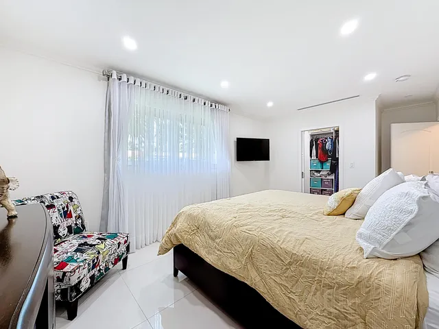 a living room with furniture kitchen view and a large window