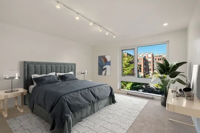 a bedroom with a large bed and a potted plant