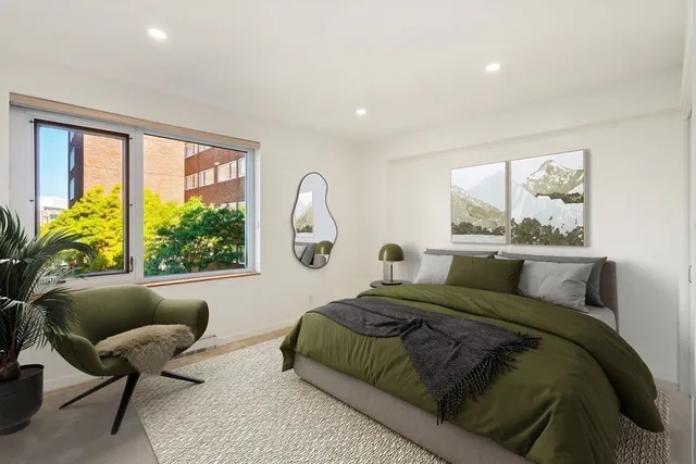 a bedroom with a bed and a large window