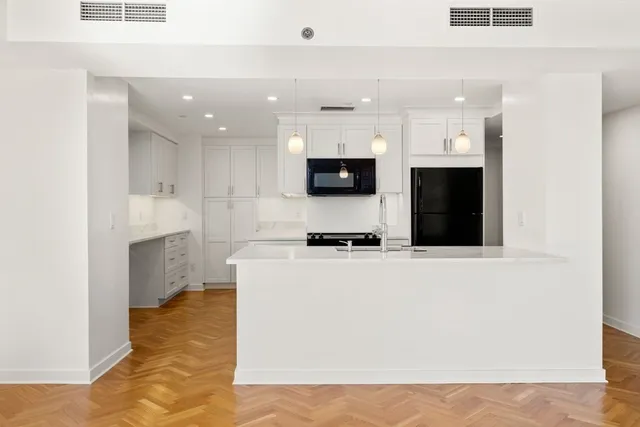 a large kitchen with stainless steel appliances a large counter top a stove a microwave and a refrigerator