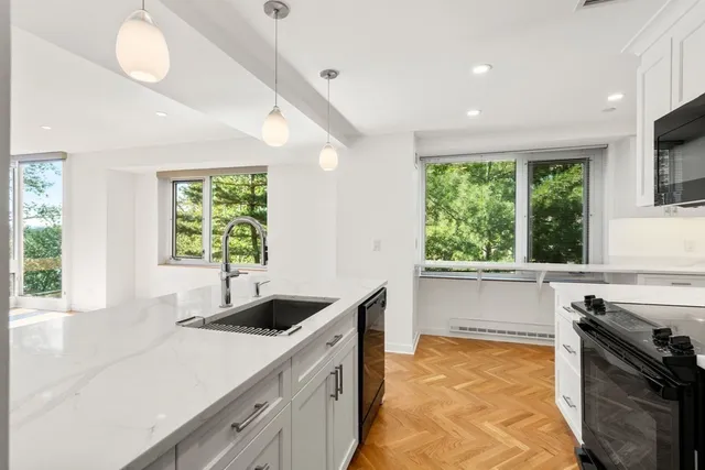 a kitchen with granite countertop a sink and a stove top oven with wooden floor