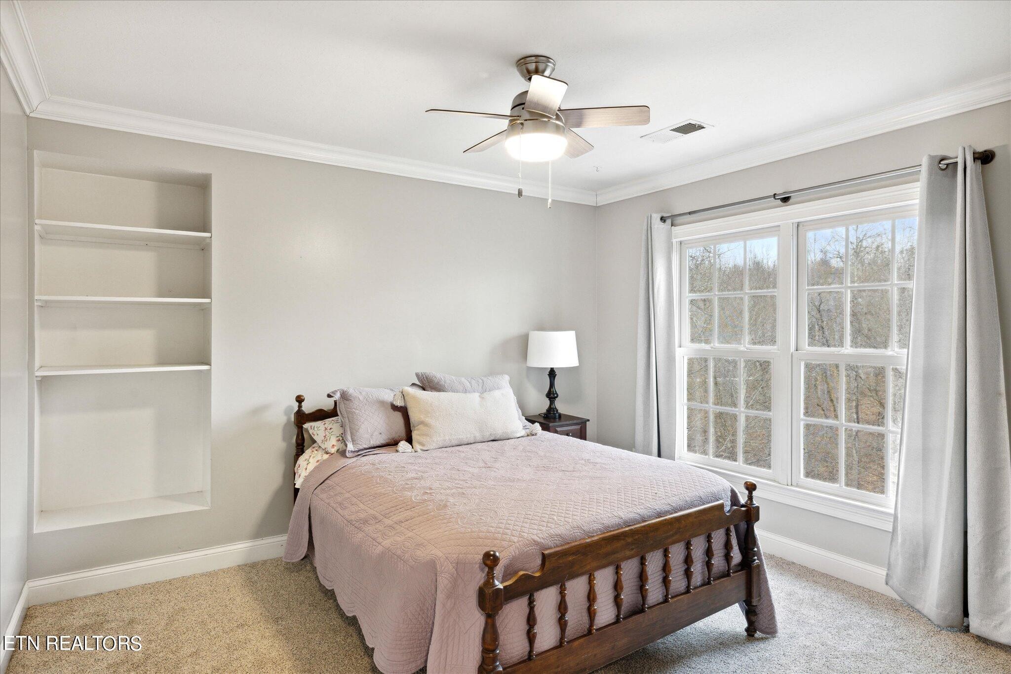 9245 Arlington Ridge Way Powell, TN 37849 - Photo 16 of 36 a bedroom with a large bed and a chandelier fan