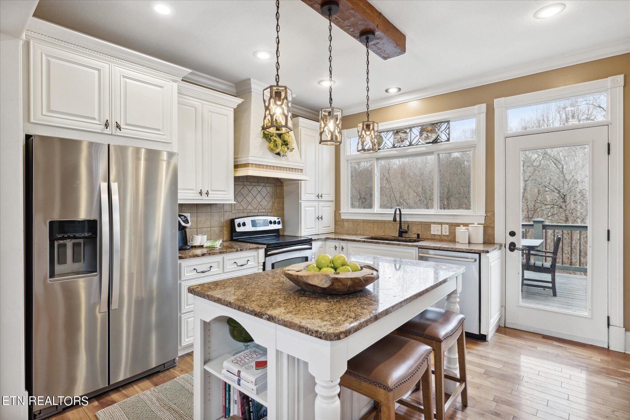 9245 Arlington Ridge Way Powell, TN 37849 - Photo 5 of 36 a kitchen with granite countertop stainless steel appliances a table chairs refrigerator and microwave