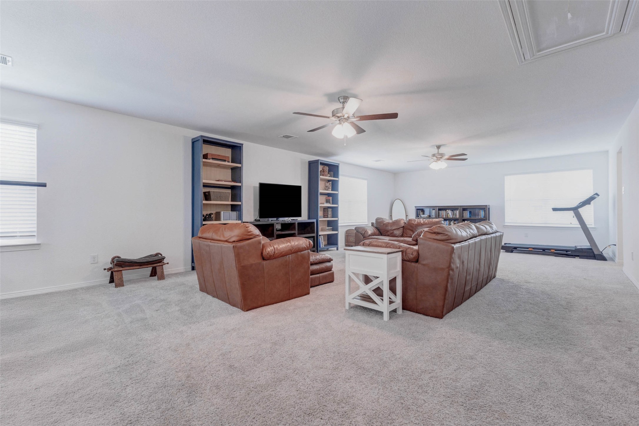 32418 Fly Fish Way Fulshear, TX 77441 - Photo 24 of 40 The expansive upstairs game room offers endless possibilities, with plush carpet, dual ceiling fans, and an abundance of natural light streaming in from multiple windows.