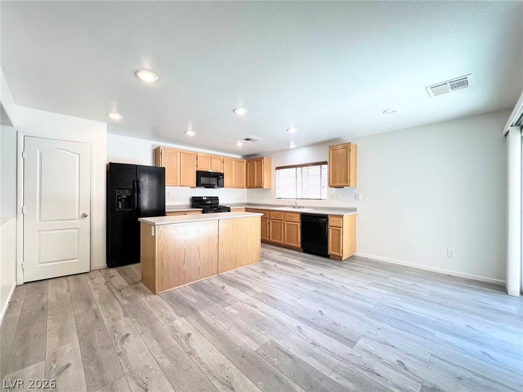 11143 Ranch Valley Street Las Vegas, NV 89179 - Photo 9 of 23 A streamlined kitchen and dining area boasts practical wood cabinetry and durable wood-look flooring.