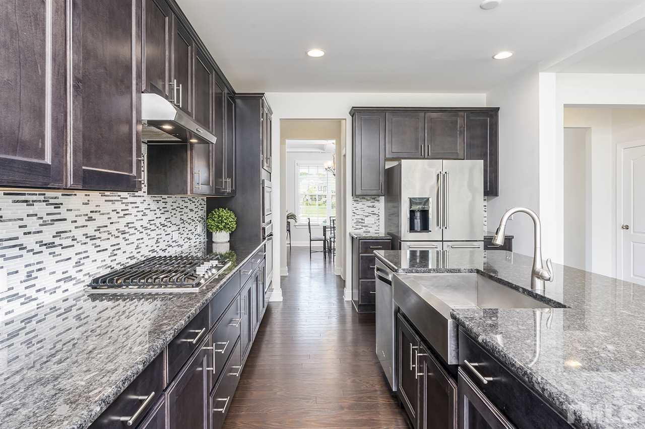 324 Morgan Ridge Road Holly Springs, NC 27540 - Photo 6 of 30 This amazing kitchen offers an over-sized island with double basin sinks, gas stove top, wall oven, & stainless steel appliances.