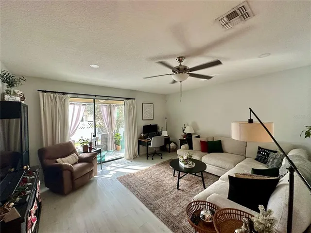 a living room with furniture floor to ceiling window and a flat screen tv