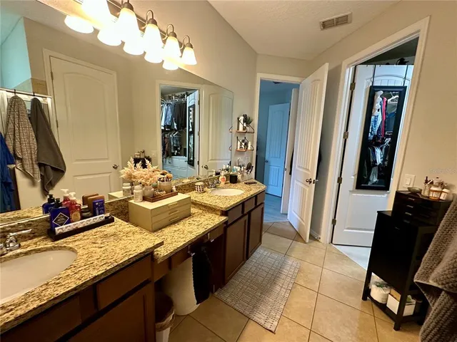 a spacious bathroom with a granite countertop sink and a mirror
