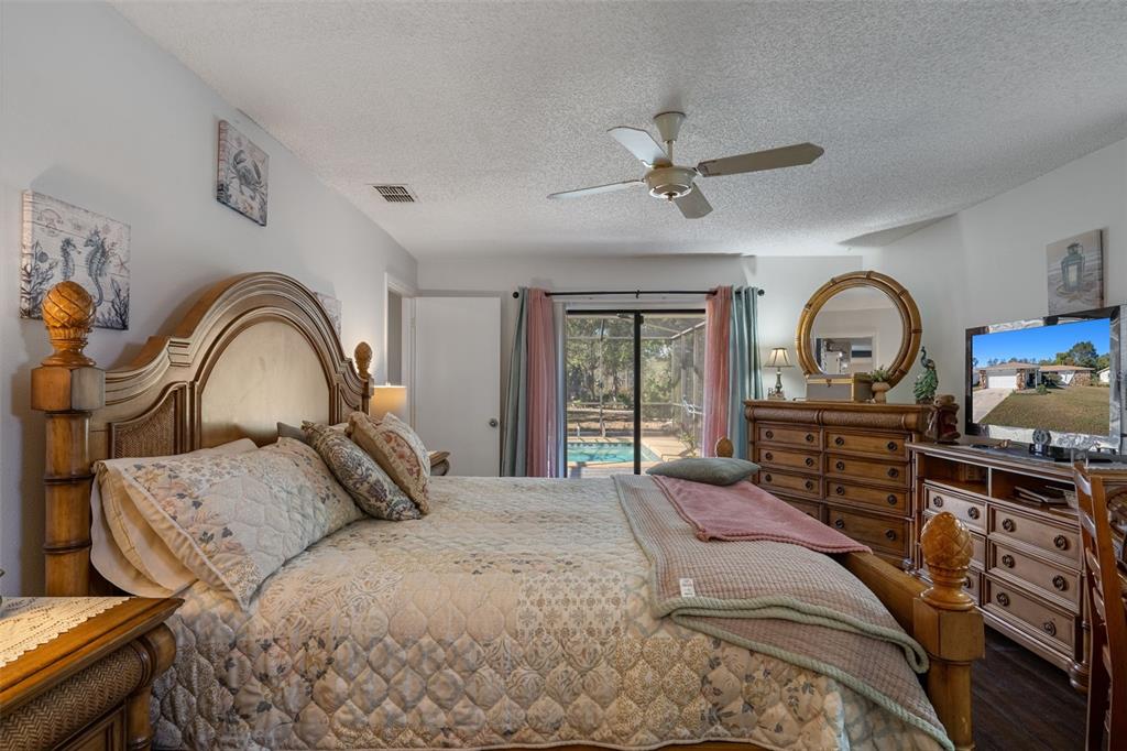 7311 Edinburgh Way Weeki Wachee, FL 34613 - Photo 14 of 27 a bedroom with a bed and a dresser with mirror