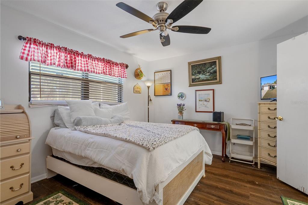 7311 Edinburgh Way Weeki Wachee, FL 34613 - Photo 19 of 27 a bedroom with a bed chandelier and a window