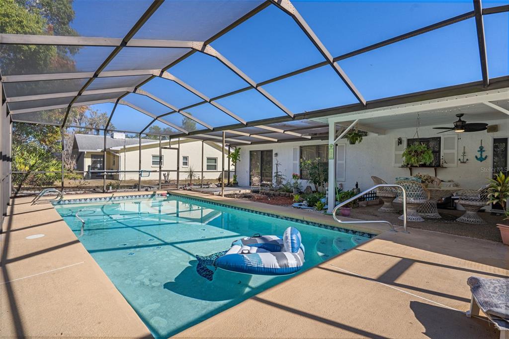 7311 Edinburgh Way Weeki Wachee, FL 34613 - Photo 24 of 27 a view of a backyard with table and chairs under an umbrella
